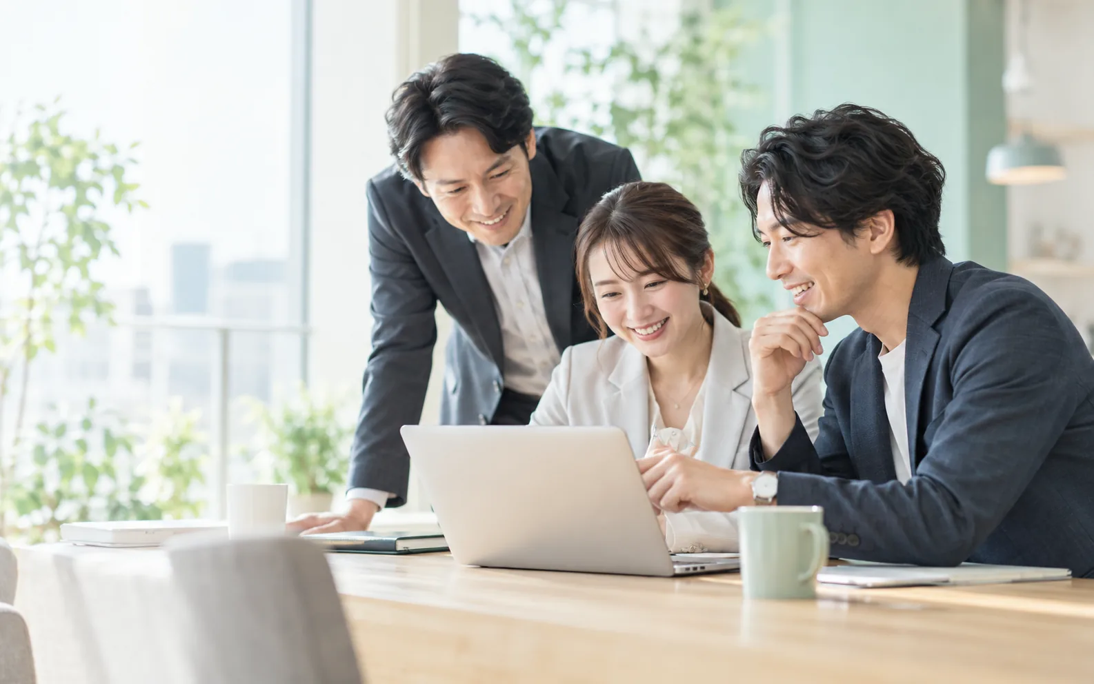 ノートパソコンを囲み、業務改善について一緒に考えるチーム